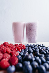 rapsberry and blueberry smoothie with fresh berries on wood tabl