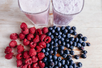 rapsberry and blueberry smoothie with fresh berries on wood tabl