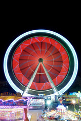 Obraz premium Colorful ferris wheel in motion at night