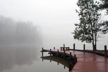 Foto op Plexiglas Dikke deken van mist bedekt meer en houten dok © blueiz60