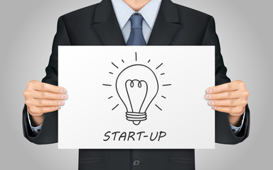 businessman holding start-up poster