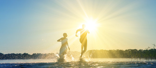 Glückliche junge Menschen laufen und springen am See beim Sonnenuntergang