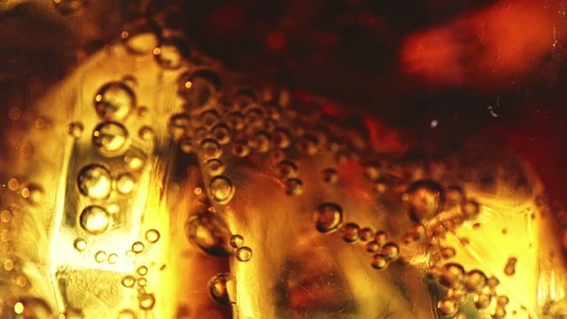 Cola with ice cubes background. Slow motion 240 fps. Cola with Ice and bubbles in a glass. Soda closeup. Food background. Cold beverage. Stock full HD video footage 1920x1080p, 1080. Dolly shot.