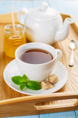 Cup of black tea with mint and honey  