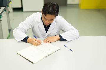 Handsome Researcher writing on his Lab-book