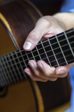 Male's hand on a classical guitar fretboard