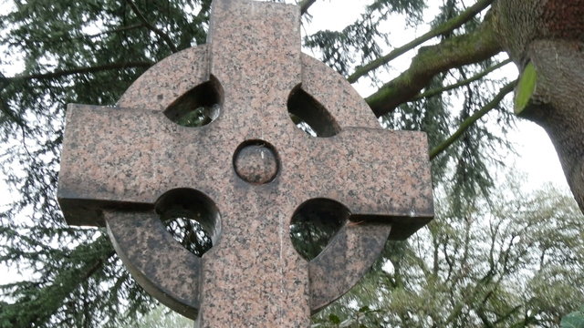 A circle with a cross tombstone in a cemetery. It is one of the tombstones found inside