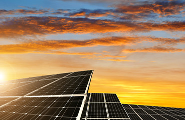 Solar energy panels against sunset sky