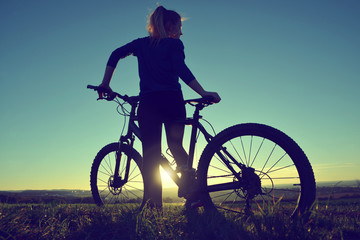 Fototapeta na wymiar Girl on a bicycle in the sunset