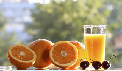 Oranges and orange juice on a green background.