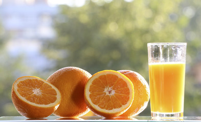 Oranges and orange juice on a green background.