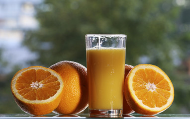 Oranges and orange juice on a green background.
