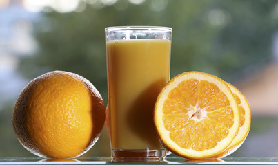 Oranges and orange juice on a green background.