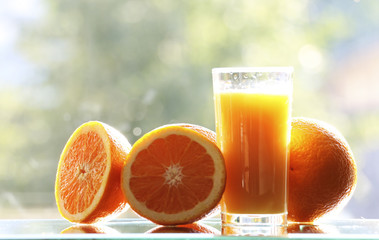 Oranges and orange juice on a green background.