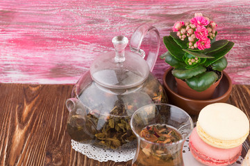Obraz na płótnie Canvas exotic green tea with flowers in glass teapot