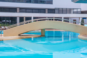 stone bridge crossing on swimming pool
