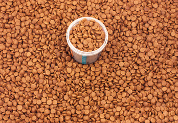 Dry brown pet food (dog or cat) with measure glass