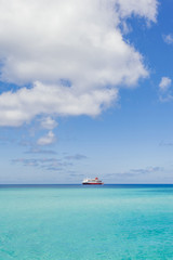 Red and white ship sailing through the ocean.