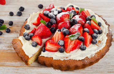 Sweet Cake with berries on  wooden background.