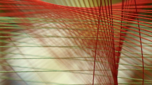 3d Image of a string tied on a cross pattern. The red string is altogether tied in a cross pattern