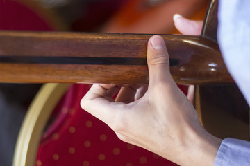 Acoustic guitar's fretboard and young male's hand