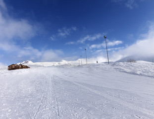 Fototapeta na wymiar Ski slope and hotel in winter mountains