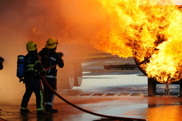Obraz premium firefighters fighting large factory fire