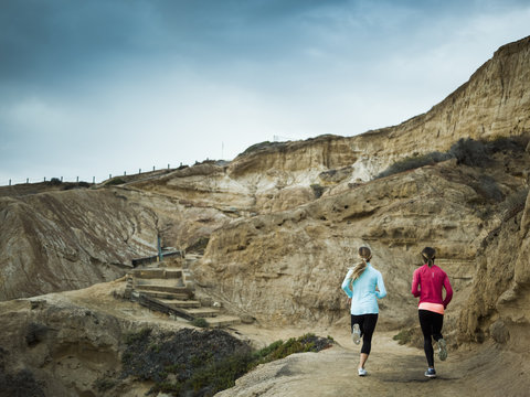 Two women jogging along a quarry trail.