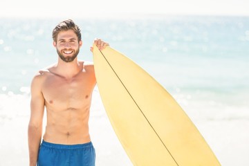 Handsome man holding surfboard 