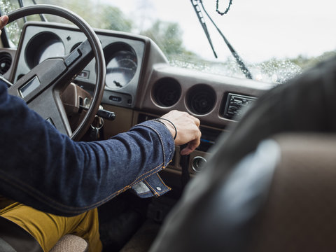 Young man in a car behind the steering wheel, driving.