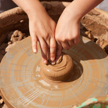 Mains d'enfant apprenant la poterie