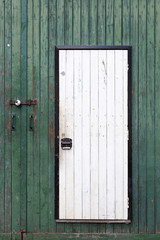 small white door in large green barn door