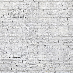 brick wall with white paint full of cracks