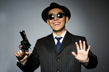 Young man in classic striped costume holding gun isolated on gra