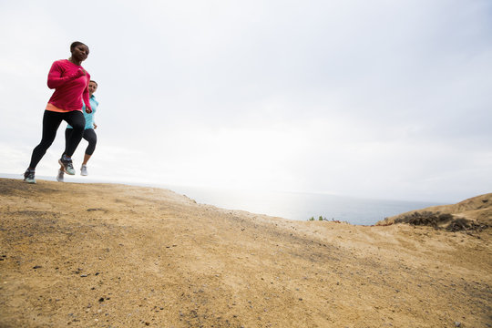 Two women jogging along the coast.