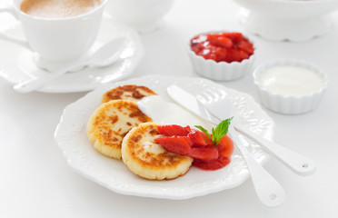 Cottage cheese pancakes with jam and sour cream for breakfast, selective focus