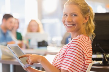 smiling young women using digital tablet