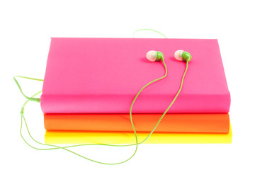 Headphones and stack of multicolored books on a white background