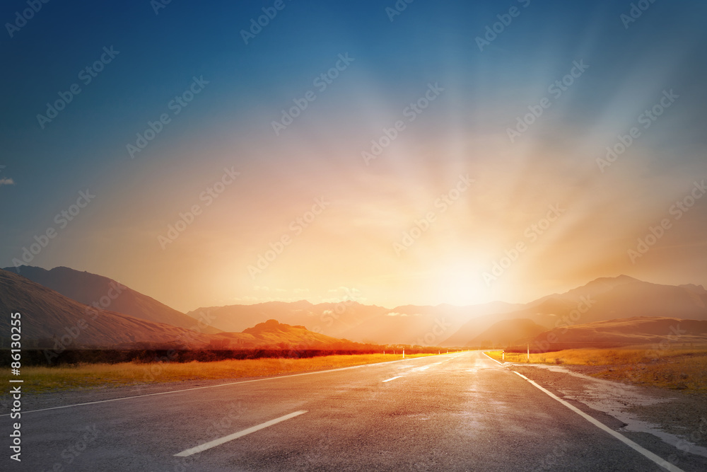 Wall mural Sunset above road