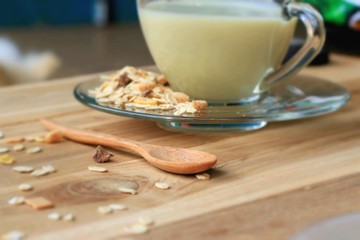 Oat flakes and milk on wooden background.