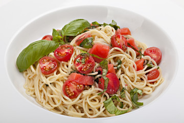 Plate of pasta with fresh tomatoes and basil .