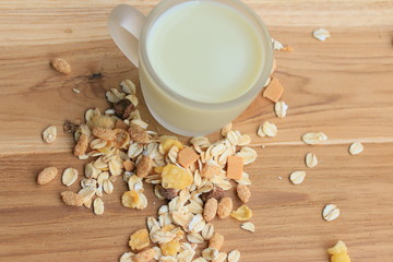 Oat flakes and milk on wooden background.