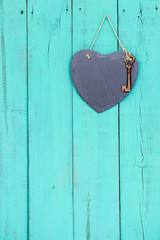 Blank slate heart with skeleton key hanging on rustic door