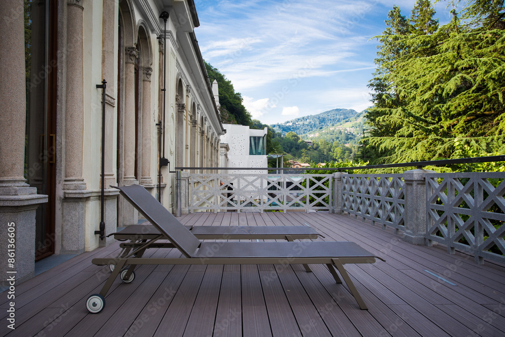 Wall mural sunbeds on the balcony with beautiful view of the mountains on t