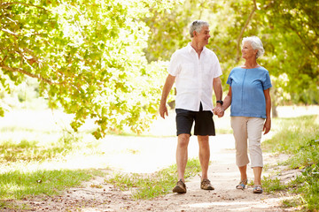 Senior couple walking on a path together in the countryside