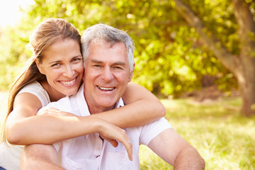 Fototapeta premium Senior man embraced by his adult daughter, outdoors