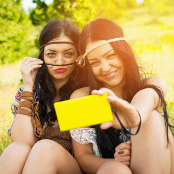 Two boho girls having fun taking a selfie