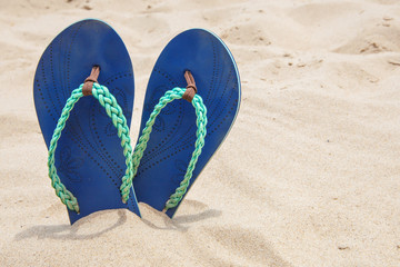 Fototapeta na wymiar Flip flops on sand