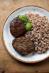 Glass plate with buckwheat and roasted beef cutlets, top view