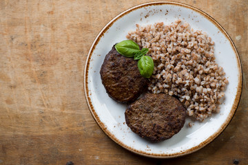 Above view of grilled meat cutlets and buckwheat, studio shot